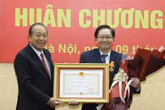Phó Thủ tướng Thường trực Trương Hòa Bình trao tặng Huân chương Độc lập hạng Nhì cho Nguyên Bộ trưởng Bộ Nội vụ Lê Vĩnh Tân. (Ảnh: Văn Điệp/TTXVN)