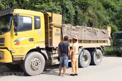 Cảnh sát giao thông kiểm tra một xe tải lưu thông trên đường. (Ảnh minh họa: TTXVN) 