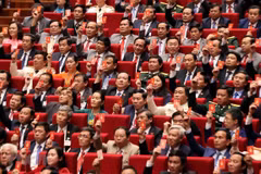 Các đại biểu biểu quyết, thông qua Nghị quyết Đại hội XIII Đảng Cộng sản Việt Nam. (Ảnh: TTXVN)