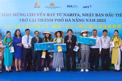 Ban tổ chức trao tặng vé khứa hồi cho hành khách may mắn trên chuyến bay đầu tiên từ Narita (Nhật Bản) đến Đà Nẵng. (Ảnh: Trần Lê Lâm/TTXVN)