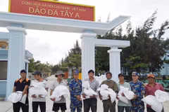 Cán bộ, chiến sỹ đảo Đá Tây đang hỗ trợ gạo cho bà con ngư dân tỉnh Ninh Thuận. (Ảnh: TTXVN phát)