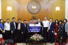 Chủ tịch Ủy ban Trung ương MTTQ Việt Nam Trần Thanh Mẫn tiếp nhận ủng hộ đồng bào miền Trung từ tập thể cán bộ, công chức, viên chức, người lao động Thông tấn xã Việt Nam. (Ảnh: Dương Giang/TTXVN)