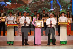 Bộ trưởng Bộ Tài Nguyên và Môi trường Nguyễn Minh Quang (trái) trao giải cho các tập thể có thành tích xuất sắc trong bảo vệ môi trường trong năm 2015. (Ảnh: Trọng Đạt/TTXVN)