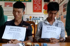 Hai đối tượng bị bắt cùng tang vật. (Ảnh: TTXVN phát)