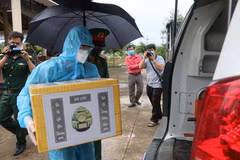 Đại diện Ban Chỉ huy quân sự huyện Châu Thành (An Giang) cùng chính quyền địa phương đã tiếp nhận, vận chuyển và bàn giao tro cốt người dân tử vong do dịch COVID-19 về tận nhà cho người thân, gia đình. (Ảnh: Công Mạo/TTXVN)