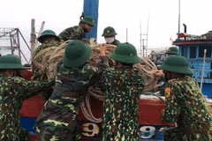 Bộ đội biên phòng Quảng Trị giúp ngư dân di chuyển ngư cụ chuẩn bị ứng phó với bão số 5. (Ảnh: Hồ Cầu/TTXVN)