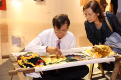 Nghệ nhân Nguyễn Xuân Dục (thôn Bình Lăng, xã Thắng Lợi, huyện Thường Tín) trình diễn tranh thêu tay. (Ảnh: Hoàng Hiếu/TTXVN)