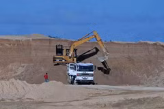 Máy xúc quặng bauxite lên một xe tải tại mỏ của Tập đoàn Khoáng sản Trung Quốc Bosai. (Nguồn: Reuters)