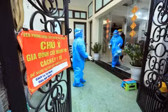 Nhân viên y tế ghi thông tin trường hợp F0 đang điều trị tại nhà tại Xóm 2, xã Tam Hiệp, huyện Thanh Trì. (Ảnh: Tuấn Anh/TTXVN)