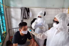 Nhân viên y tế đo thân nhiệt kiểm tra sức khỏe đối với công nhân phải cách ly. (Ảnh: Dương Chí Tưởng/TTXVN)