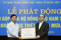 Chủ tịch Ủy ban Trung ương MTTQ Việt Nam Nguyễn Thiện Nhân tiếp nhận 100 triệu đồng của Trung ương Đoàn Thanh niên Cộng sản Hồ Chí Minh ủng hộ đồng bào Nam Trung Bộ. (Ảnh: Nguyễn Dân/TTXVN) 