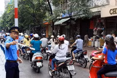 Thanh tra giao thông hướng dẫn người dân đi đúng làn đường trên tuyến phố Huế-Hàng Bài, Hà Nội. (Ảnh: Thế Duyệt/TTXVN)