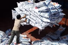 Công nhân bốc xếp phân bón xuống xà lan. (Ảnh: Thanh Phàn/TTXVN