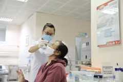 Nhân viên y tế lấy mẫu xét nghiệm cho người dân tới khám. (Ảnh: TTXVN/Vietnam+)