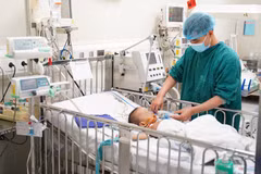 Các bác sỹ điều trị cho bệnh nhi. (Ảnh: PV/Vietnam+)