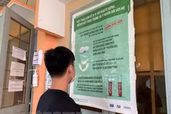 Các bạn trẻ đọc thông tin tuyên truyền về phòng chống HIV/AIDS. (Ảnh: T.G/Vietnam+)