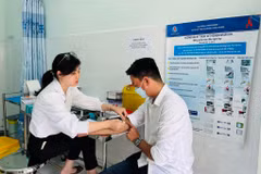 Nhân viên y tế Trung tâm Kiểm soát bệnh tật tỉnh Kiên Giang lấy mẫu xét nghiệm theo dõi điều trị HIV cho một bệnh nhân. (Ảnh: T.G/Vietnam+)