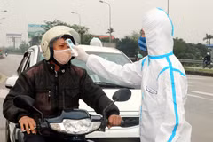 Kiểm tra thân nhiệt các trường hợp từ nơi khác đi qua địa bàn tỉnh tại chốt kiểm soát dịch COVID-19. (Ảnh: Văn Đạt/TTXVN)