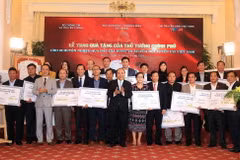 Thủ tướng Nguyễn Xuân Phúc trao tặng tiền số tiền cho 20 huyện nghèo qua đấu giá trái bóng và áo Đội tuyển U23 Việt Nam. (Ảnh: Thống Nhất/TTXVN)