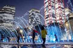 Trẻ em vui chơi dưới đài phun nước dọc sông Hàn ở Thủ đô Seoul (Hàn Quốc). (Ảnh: Yonhap/TTXVN)