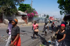 Người dân chạy trốn khỏi khu vực xảy ra đụng độ ở Port-au-Prince (Haiti), ngày 20/3/2024. (Ảnh: AFP/TTXVN)