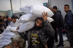 Người tị nạn Palestine nhận hàng viện trợ của UNRWA tại thành phố Rafah, Dải Gaza ngày 3/3/2024. (Ảnh: AFP/TTXVN)