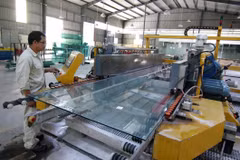 Sản xuất kính cường lực tại Công ty Cổ phần Sản xuất và Thương mại Tân Minh. (Ảnh: TTXVN)