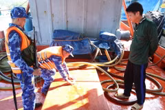 Lực lượng chức năng niêm phong hàng hóa vi phạm trên tàu. (Ảnh: TTXVN phát)