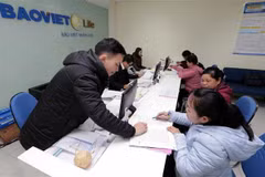 Hướng dẫn khách hàng làm thủ tục bảo hiểm tại Bảo Việt Nhân thọ Cao Bằng. (Ảnh: Trần Việt/TTXVN)