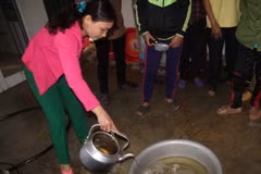 Nước giếng gia đình chị Thái Thị Hiên sau khi múc lên có màu vàng và bốc mùi dầu nồng nặc. (Ảnh: Phan Quân/TTXVN)