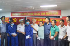 Chuẩn đô đốc Ngô Văn Thuân và lãnh đạo các cơ quan tìm kiếm cứu nạn và địa phương động viên tinh thần các ngư dân gặp nạn đã trở về đất liền an toàn. (Ảnh: Phan Sáu/TTXVN)