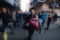 Chuyển em nhỏ bị thương trong vụ oanh tạc của Israel xuống thành phố Rafah, phía Nam Dải Gaza. (Ảnh: AFP/TTXVN)