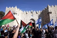 Người dân Palestine và Israel vẫy cờ bên ngoài cổng Damascus hôm 8/5. (Nguồn: AFP)