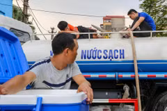 Người dân Thủ đô đang lấy nước miễn phí tại Nhà máynước Hạ Đình. (Ảnh: Minh Sơn/Vietnam+)