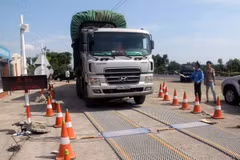 Lực lượng chức năng tiến hành kiểm tra trọng tải xe. (Ảnh: Thế Lập/TTXVN) 