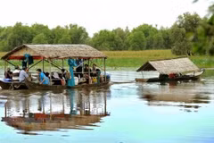 Du khách tham quan Vườn quốc gia Tràm Chim bằng nhà nổi trên sông. (Ảnh: An Hiếu/TTXVN) 