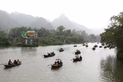Những con đò tiếp nối nhau trên suối Yến, đưa du khách hành hương lễ Phật. (Ảnh: Thành Đạt/TTXVN) 