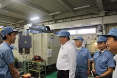 Đại sứ Việt Nam tại Nhật Bản Đoàn Xuân Hưng đang hỏi thăm một thực tập sinh tại Nhà máy. (Nguồn: Hữu Thắng/Vietnam+) 