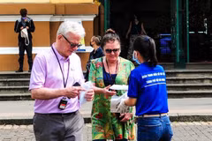 Nhân viên Sở Du lịch Thành phố Hồ Chí Minh phát khẩu trang miễn phí cho khách du lịch nước ngoài. (Ảnh: Đinh Hằng/TTXVN)