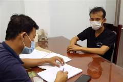 Lấy lời khai của đối tượng đánh bạc đã bị bắt giữ. (Ảnh: Công Thử/TTXVN)