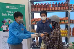 Người nghèo nhận hàng hóa và khẩu trang miễn phí. (Ảnh: Xuân Triệu/TTXVN)