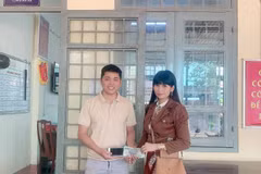 Anh Khánh trao trả tài sản nhặt được cho chị Vân. (Ảnh: TTXVN phát)