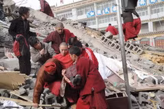 Người dân chuyển những người bị thương ra khỏi đống đổ nát sau trận động đất. (Nguồn: THX/TTXVN)