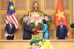 Tổng Giám đốc Thông tấn xã Việt Nam Vũ Việt Trang và Tổng biên tập Hãng thông tấn quốc gia Malaysia (BERNAMA) Khairdzir Md Yunus trao đổi Thỏa thuận hợp tác nghiệp vụ giữa Thông tấn xã Việt Nam và Hãng thông tấn quốc gia Malaysia. (Ảnh: Dương Giang/TTXVN)