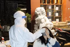 Lực lượng y tế test nhanh kháng nguyên SARS-CoV-2 tất cả người vi phạm. (Ảnh: Tuấn Anh/TTXVN) 