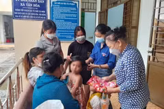 Các hội, đoàn thể của huyện và xã Tân Hòa sửa soạn cho bé L.Y.D trước khi bé về quê cùng cha ruột. (Ảnh: Đậu Tất Thành/TTXVN) 