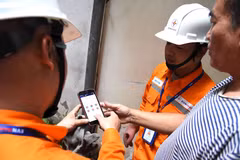 Nhân viên EVNHANOI hướng dẫn khách hàng kiểm tra hóa đơn điện ngay trên App EVNHANOI. (Ảnh: evnhanoi)