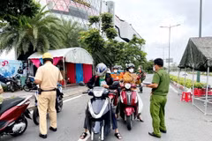 Lực lượng Công an tại chốt kiểm trên đường Phạm Văn Đồng, phường Hiệp Bình Chánh, Thủ Đức, kiểm tra giấy tờ của người lưu thông. (Ảnh: Thành Chung/TTXVN)