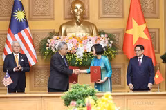 Tổng Giám đốc TTXVN Vũ Việt Trang và Tổng Biên tập Hãng thông tấn quốc gia Malaysia (BERNAMA) Khairdzir Md Yunus trao đổi Thỏa thuận hợp tác nghiệp vụ giữa 2 hãng thông tấn. (Ảnh: Dương Giang/TTXVN)