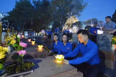 Bí thư Trung ương Đoàn, Chủ tịch Trung ương Hội Sinh viên Việt Nam Nguyễn Minh Triết, Bí thư Đoàn Khối Doanh nghiệp Trung ương Hoàng Thị Minh Thu thắp nến tri ân các Anh hùng Liệt sỹ. (Ảnh: Minh Đức/TTXVN)